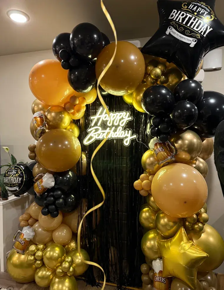 Black and gold birthday backdrop with a neon Happy Birthday sign