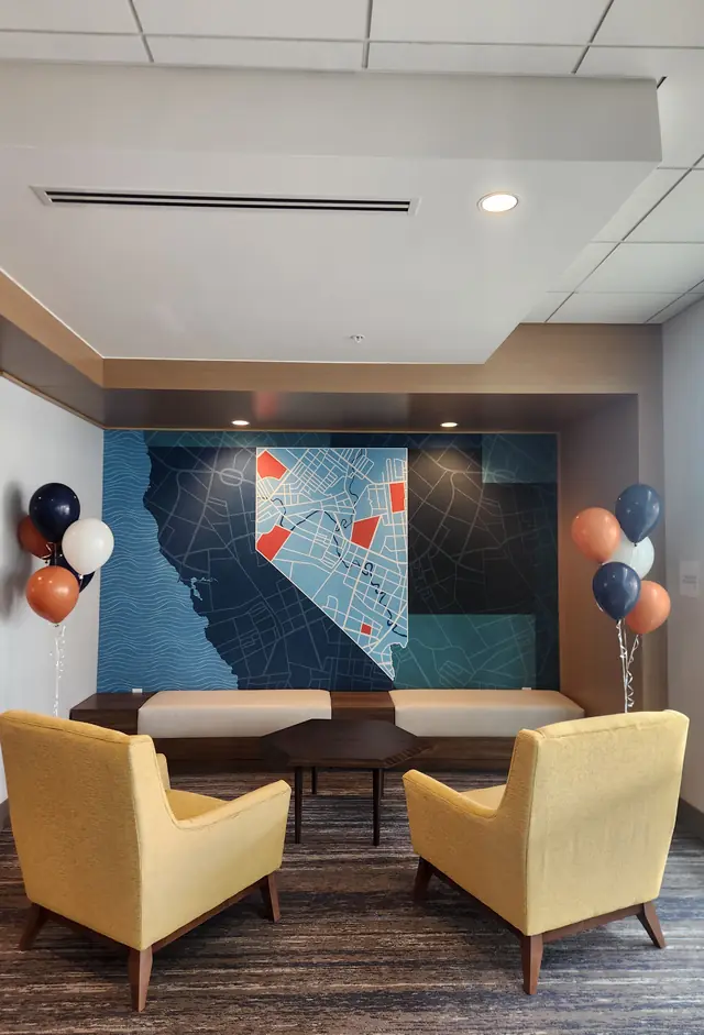 Navy, orange, and white balloon bouquets on either side of a hotel lobby lounge
